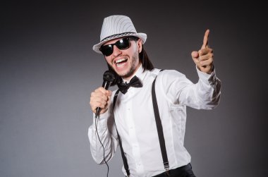 Konserde mikrofonlu komik bir şarkıcı.