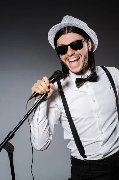 Śmieszny piosenkarz z mikrofonem na koncercie — Zdjęcie stockowe