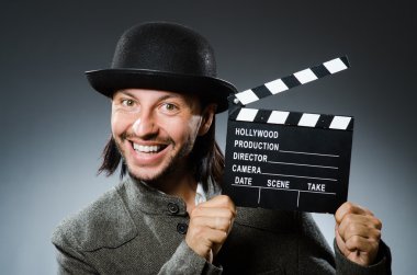 Film alkışları ve şapkası olan adam.