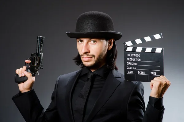 Man with gun and movie clapboard — Stock Photo, Image