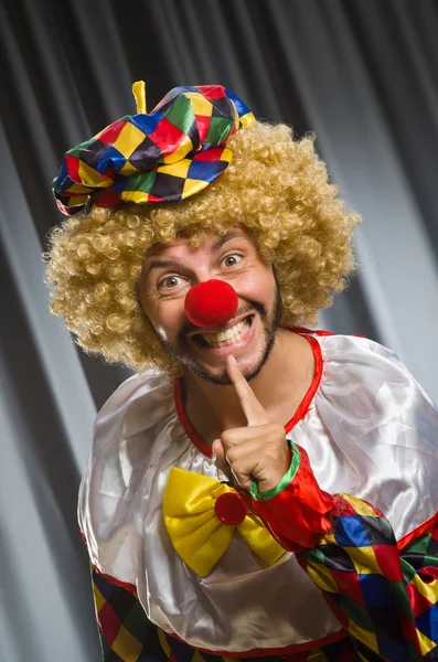 Clown divertente nel concetto umoristico contro tenda — Foto Stock