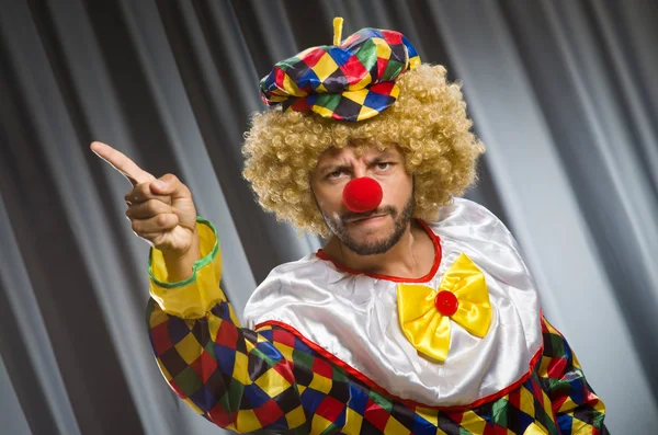 Clown divertente nel concetto umoristico contro tenda — Foto Stock