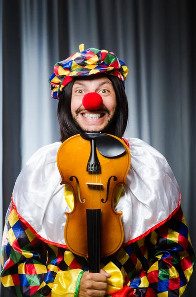 Engraçado palhaço plyaing violino contra cortina — Fotografia de Stock