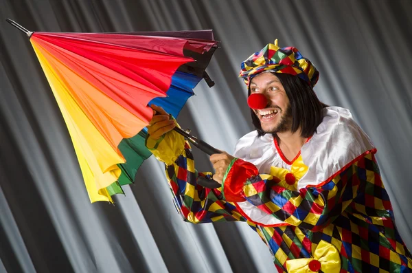 Grappige clown met kleurrijke paraplu — Stockfoto