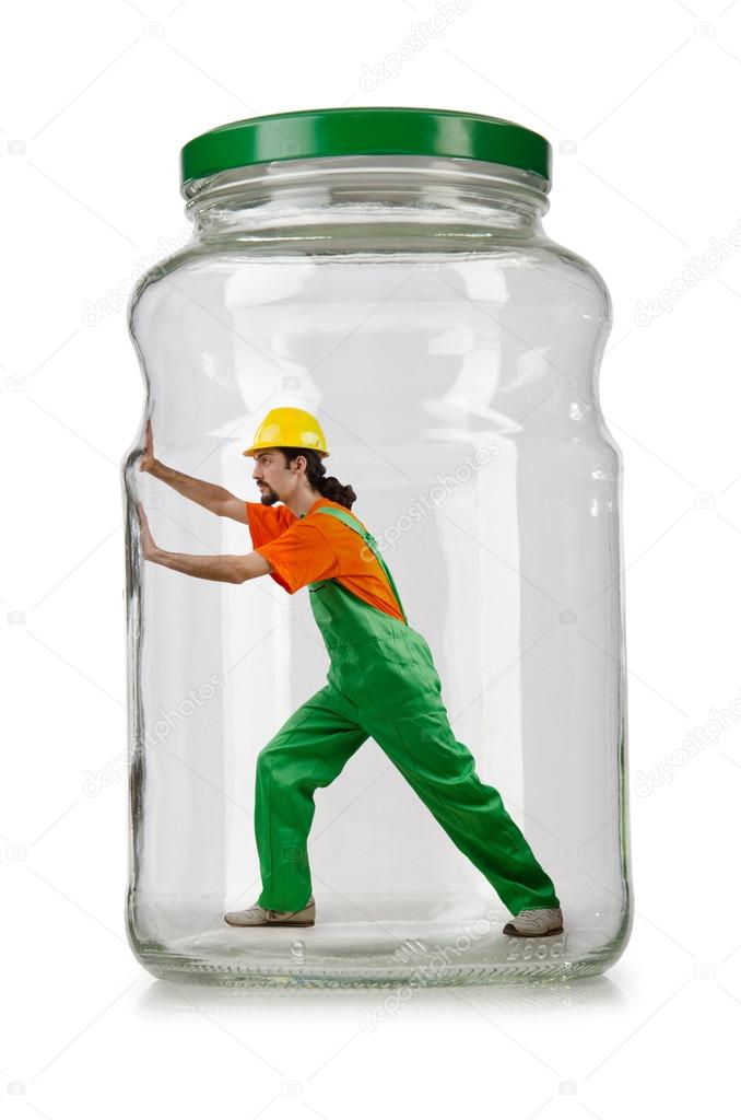 Man in coveralls imprisoned in glass jar