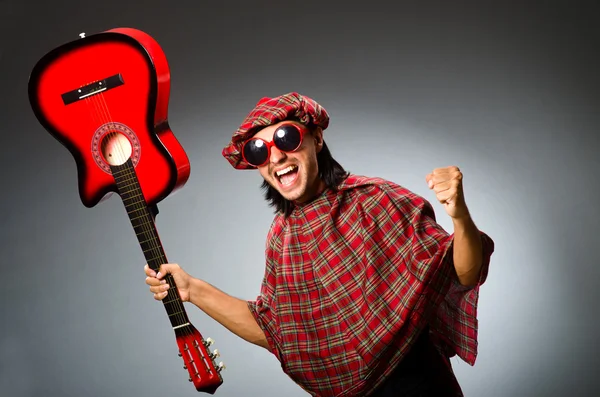 Divertido escocés tocando la guitarra roja — Foto de Stock
