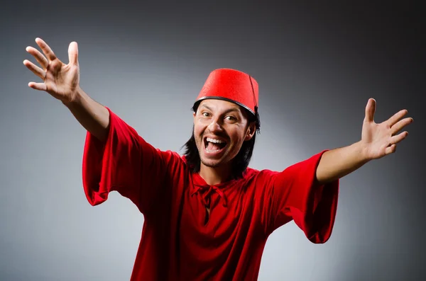 Egy piros ruhás férfi fez kalapban. — Stock Fotó