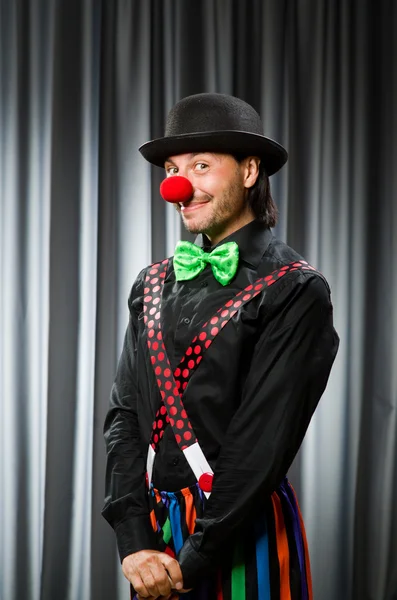 Lustiger Clown mit humorvollem Konzept gegen Vorhang — Stockfoto