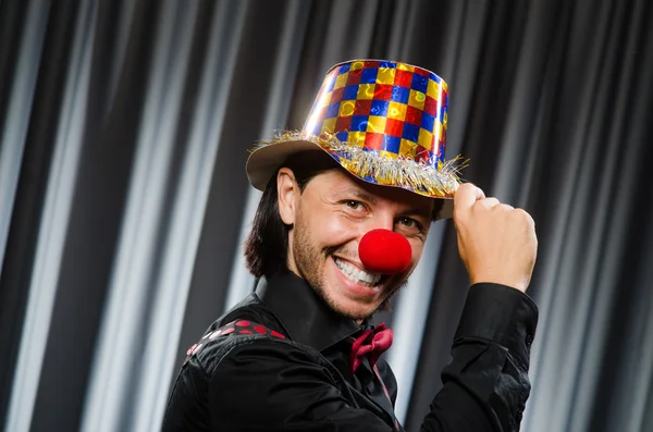 Смішний клоун в гумористичній концепції проти штор — стокове фото