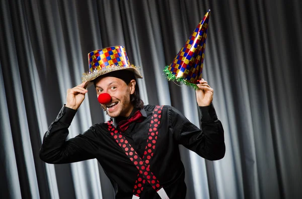 Rolig clown i humoristiskt koncept mot gardin — Stockfoto
