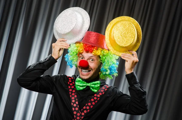 Clown divertente nel concetto umoristico contro tenda — Foto Stock