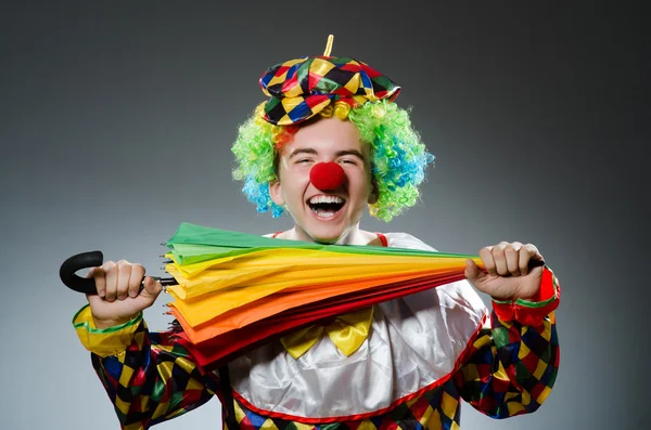 Grappige clown met kleurrijke paraplu — Stockfoto