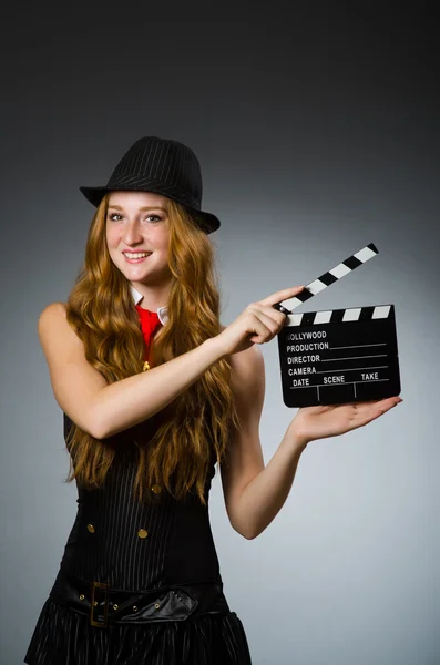 Vrouw met filmklapbord tegen grijze achtergrond — Stockfoto