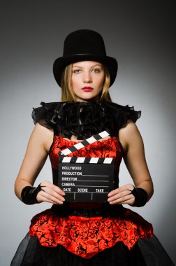 Gri arka planda film panosu olan bir kadın.