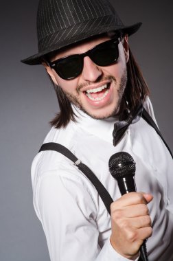 Konserde mikrofonlu komik bir şarkıcı.