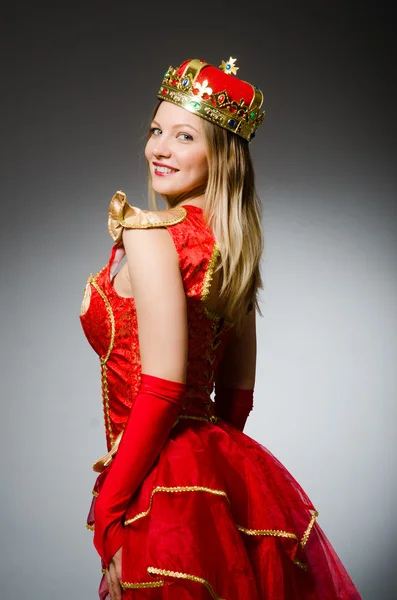 Queen in red costume against dark background — Stock Photo, Image