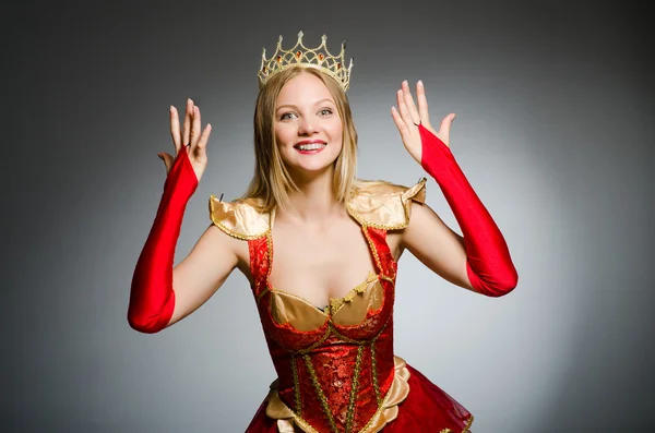 Queen in red costume against dark background — Stock Photo, Image