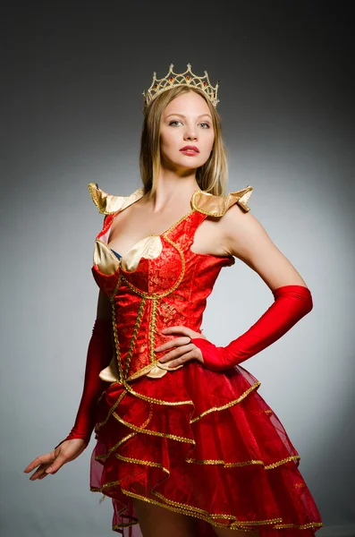 Koningin in rood kostuum tegen donkere achtergrond — Stockfoto