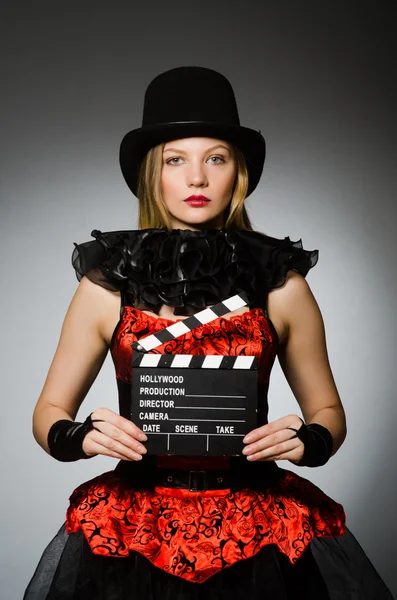 Mulher com filme clapboard contra fundo cinza — Fotografia de Stock