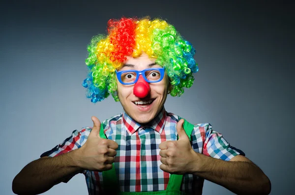 Grappige clown tegen de donkere achtergrond — Stockfoto