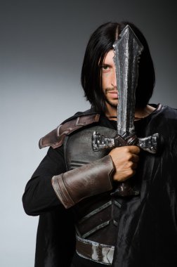 Karanlık arka planda kılıçlı kızgın bir şövalye