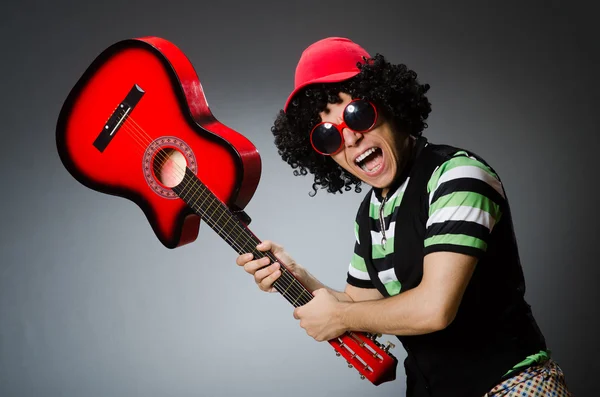 Мужчина со смешной стрижкой и гитарой — стоковое фото