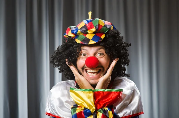 Clown divertente nel concetto umoristico contro tenda — Foto Stock