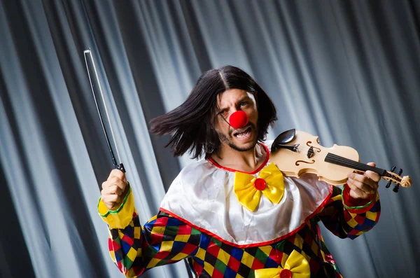 Engraçado palhaço plyaing violino contra cortina — Fotografia de Stock