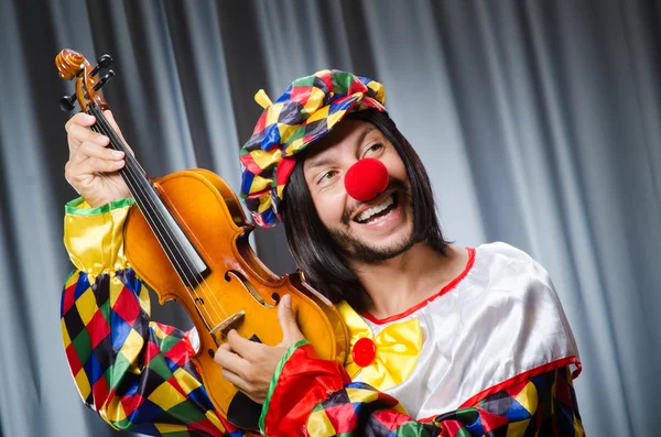 Αστείος κλόουν παίζει βιολί ενάντια στην κουρτίνα — Φωτογραφία Αρχείου