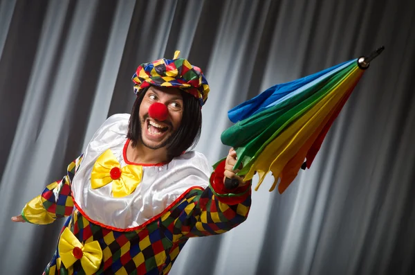 Lustiger Clown mit buntem Regenschirm — Stockfoto