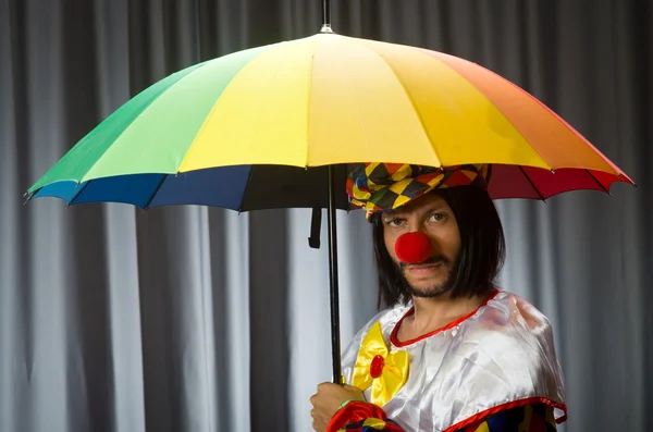 Grappige clown met kleurrijke paraplu — Stockfoto