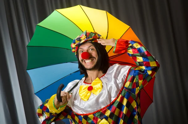 Grappige clown met kleurrijke paraplu — Stockfoto