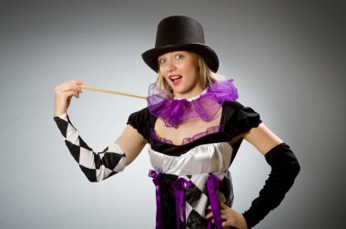 Kadın sihirbaz değnekle numaralarını yapıyor.