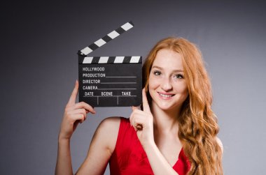 Film tahtası olan kırmızı elbiseli bir kadın.