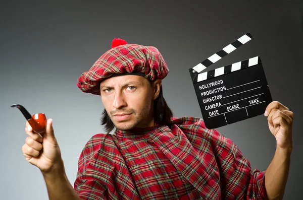 Смешной шотландец с кинодоской и курительной трубкой — стоковое фото