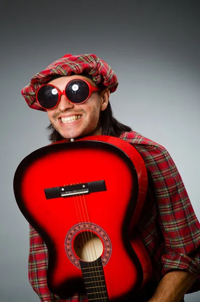 Funny scotsman playing red guitar — Stock Photo, Image