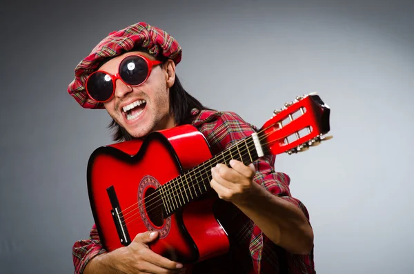 Escoteiro engraçado tocando guitarra vermelha — Fotografia de Stock