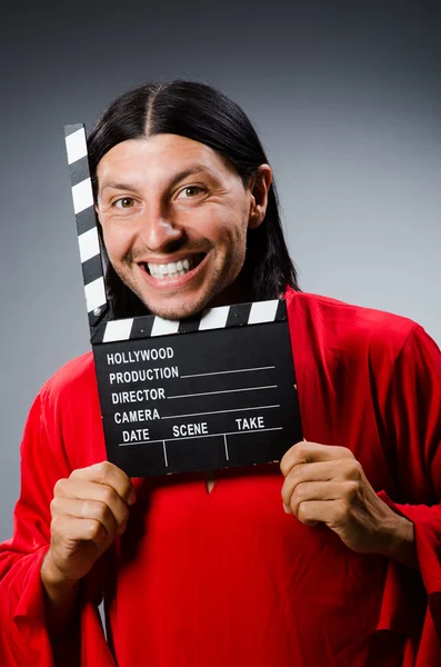 Man in red dress with movie clapboard — Stock Photo, Image