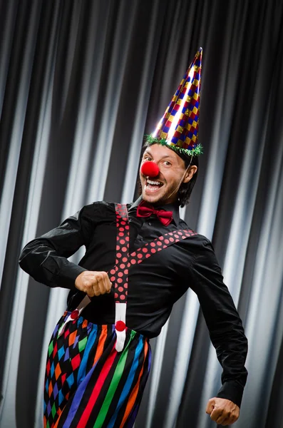 Grappige clown in humoristische concept tegen gordijn — Stockfoto