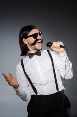 Konserde mikrofonlu komik bir şarkıcı.