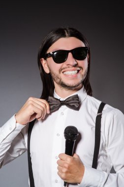 Konserde mikrofonlu komik bir şarkıcı.