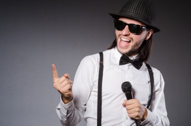 Konserde mikrofonlu komik bir şarkıcı.