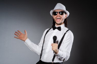 Konserde mikrofonlu komik bir şarkıcı.