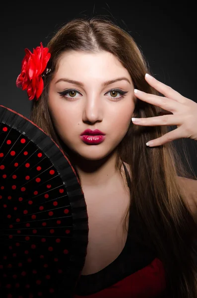 Beautiful young woman with flower and fan — Stock Photo, Image