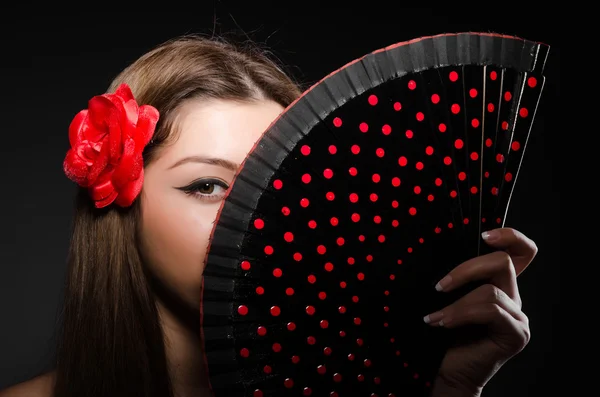 Beautiful young woman with flower and fan — Stock Photo, Image