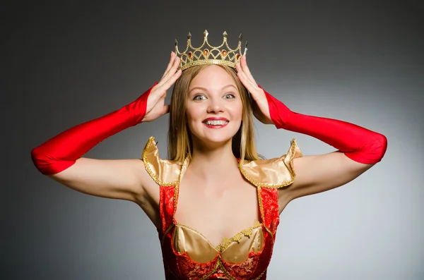 Queen in red costume against dark background — Stock Photo, Image