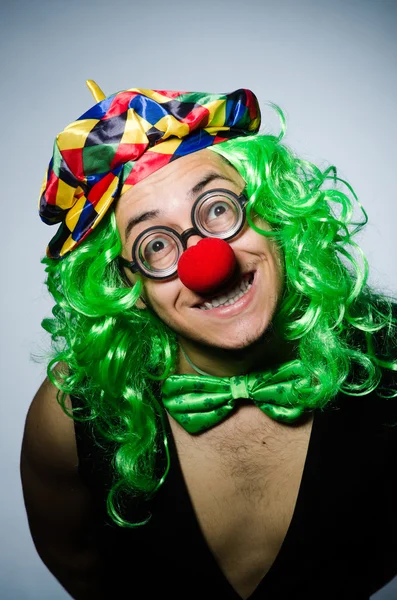 Grappige clown tegen de donkere achtergrond — Stockfoto