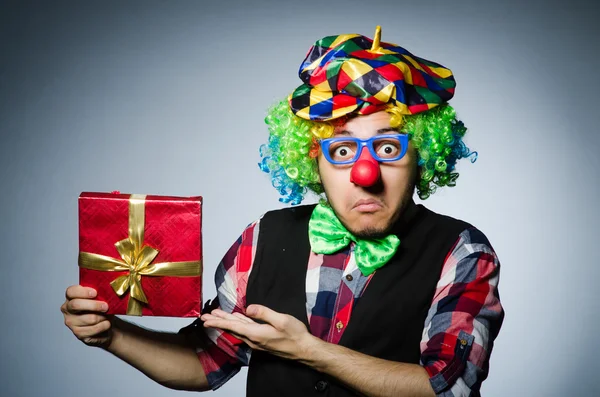 Смешной клоун с красным подарком — стоковое фото