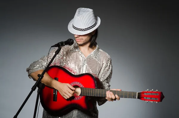 Человек с гитарой поет с микрофоном — стоковое фото
