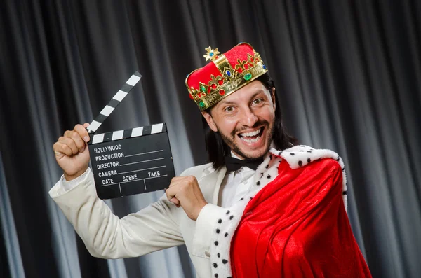 König mit Filmtafel in lustigem Konzept — Stockfoto